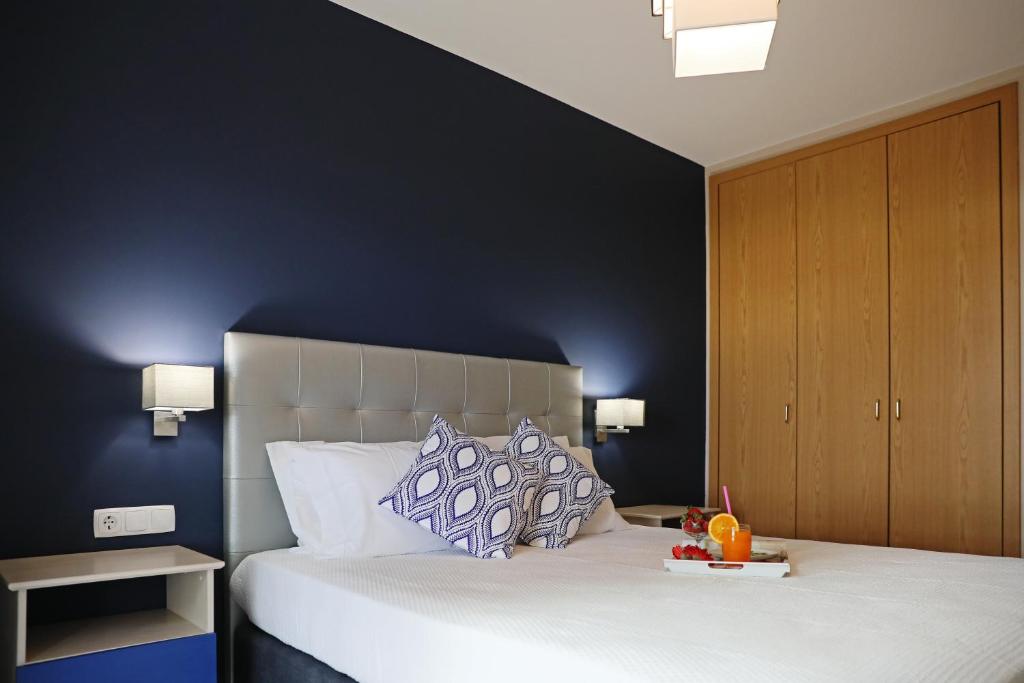 um quarto com uma cama grande e uma parede azul em RochaBay Apartment em Portimão
