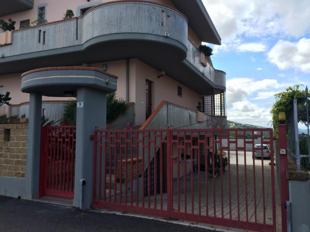 una cerca roja frente a una casa en B&B Mirella, en Citta' Sant'Angelo