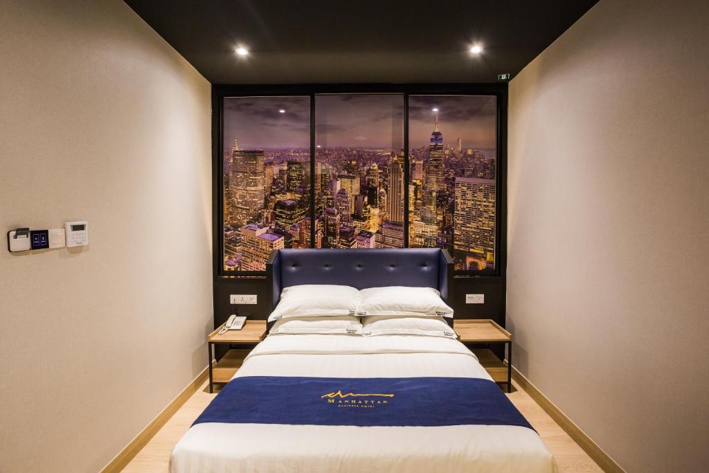Bett in einem Zimmer mit einem großen Fenster in der Unterkunft Manhattan Business Hotel TTDI in Petaling Jaya
