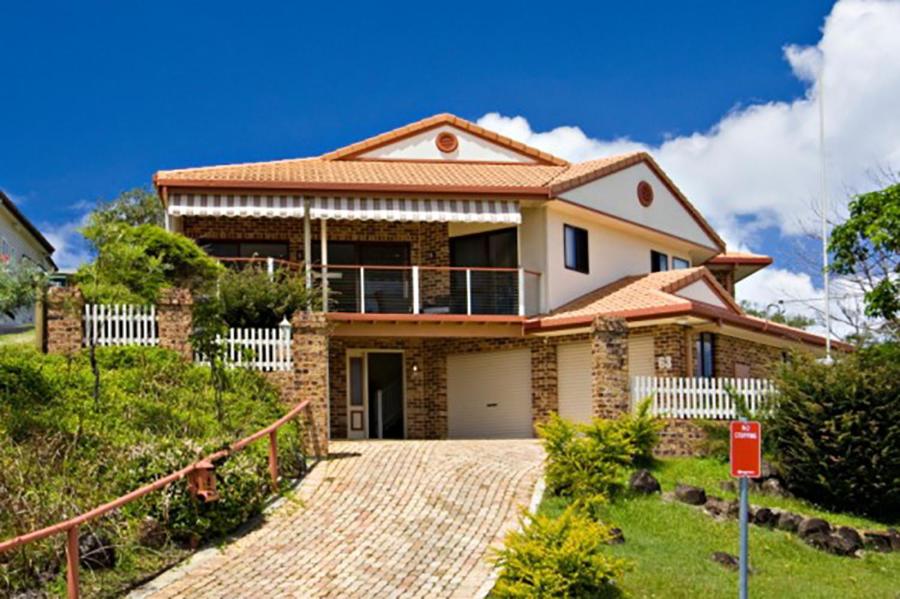 a brick house with a porch and a driveway at Away on Massinger Street in Byron Bay