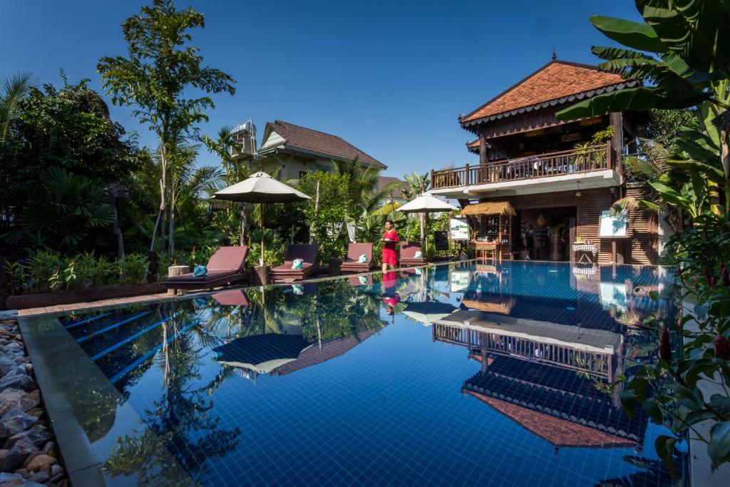 a swimming pool in front of a house at Java Wooden Villa & Residence in Siem Reap