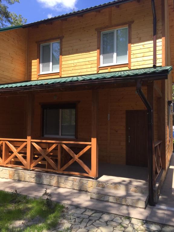 a house with a wooden fence in front of it at Cottage in Sosnovom Boru in Koblevo