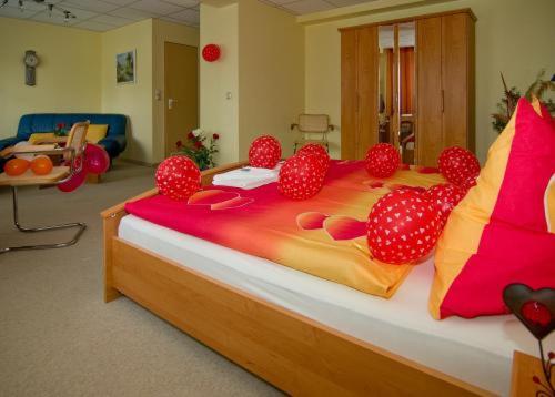 uma cama grande com pompons em cima em Waldhotel Seelow em Seelow