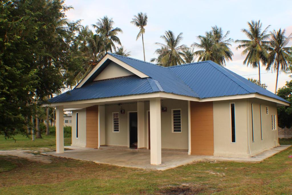 una pequeña casa con techo azul en Maxim Apartment, en Pantai Cenang