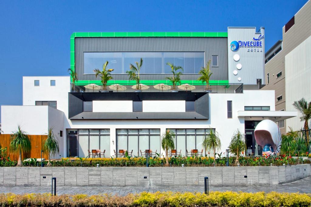 a building with palm trees on top of it at Divecube Hotel in Taichung