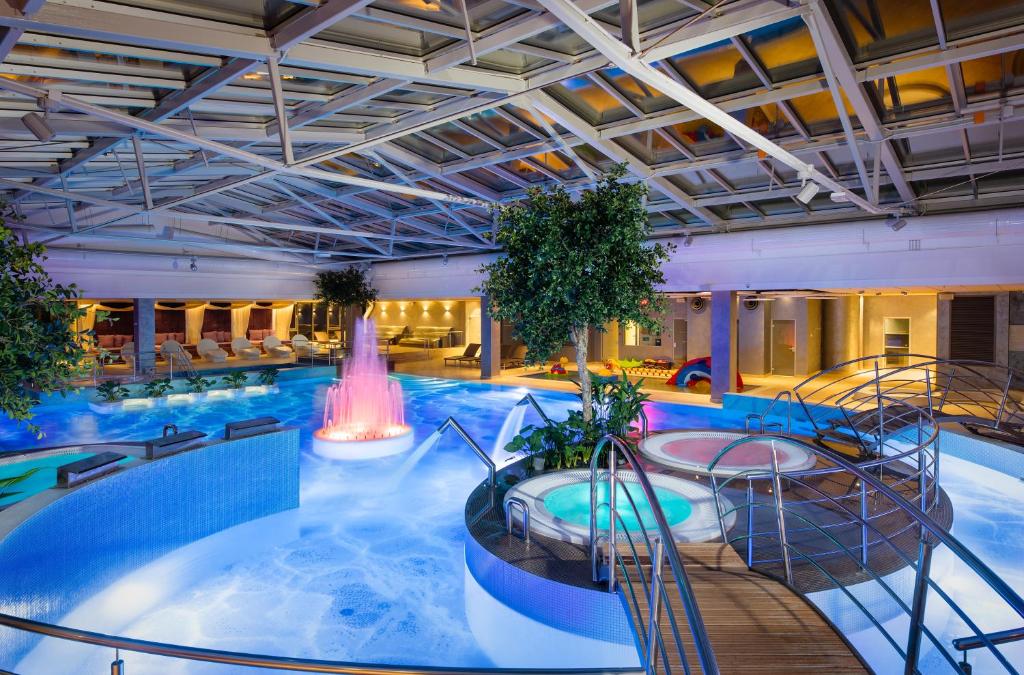 a large swimming pool with a fountain in a building at V Spa & Conference Hotel in Tartu