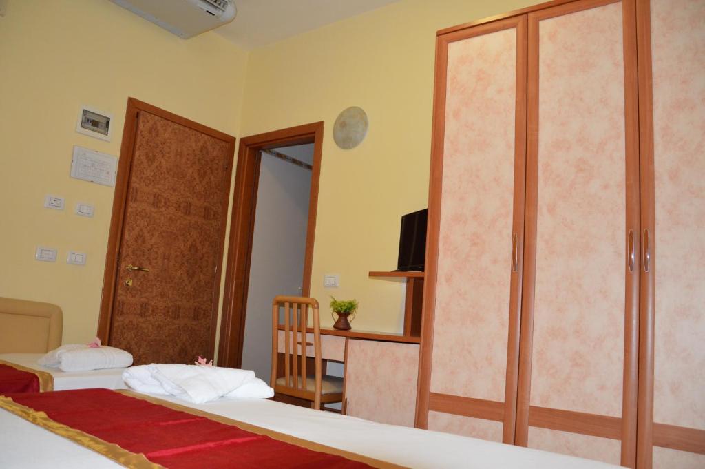 a bedroom with two beds and a sliding glass door at Hotel Carolin in Rimini