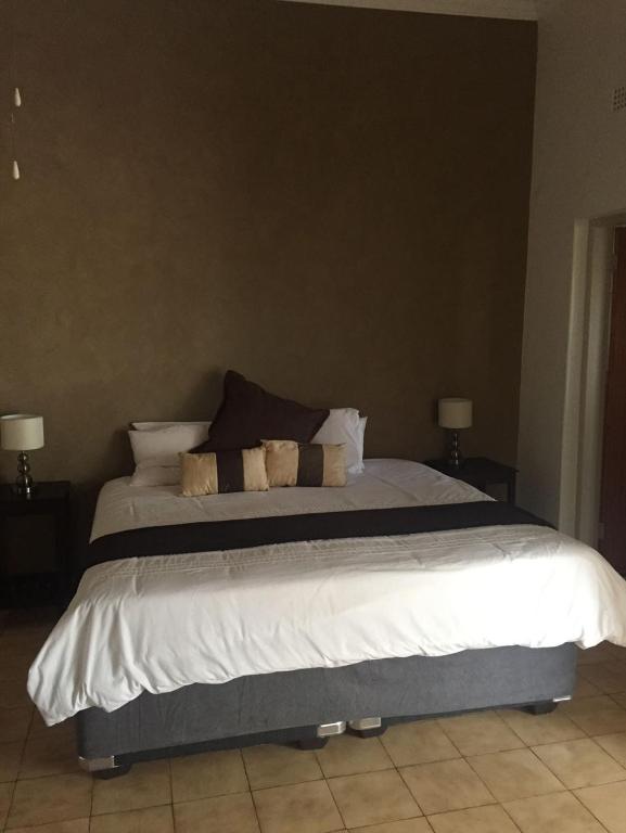 a bedroom with a bed with white sheets and pillows at Baobab Lane Lodge in Marnitz