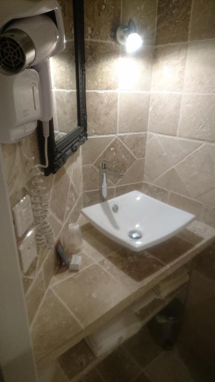 a bathroom with a white sink and a mirror at Le Grand Hotel in Aups