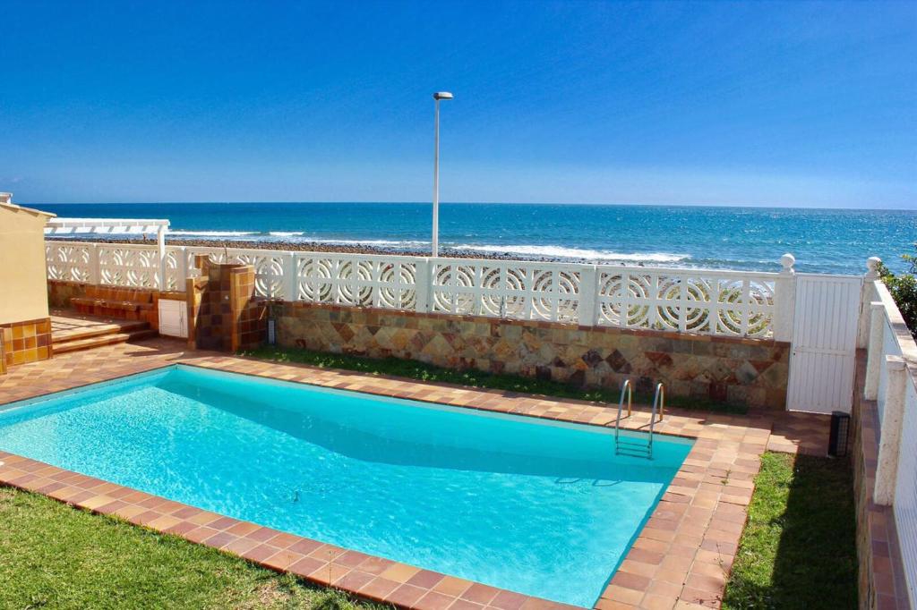 a swimming pool with the ocean in the background at Bungalow Paraiso El Mar 3 in San Agustin