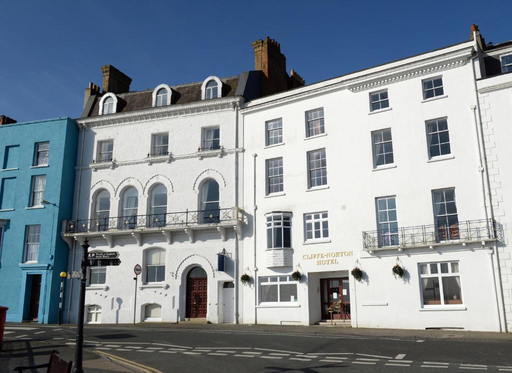 a white building on the corner of a street at Cliffe Norton in Tenby