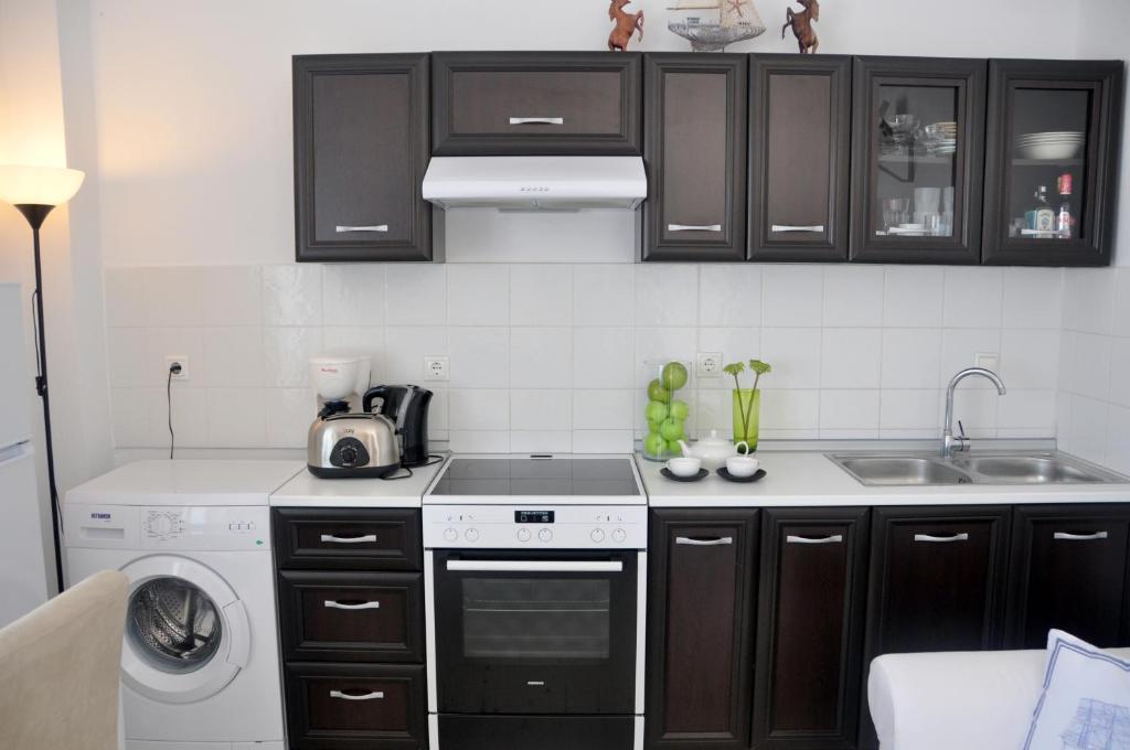 a kitchen with a stove top oven next to a sink at Marine House Andrianna -Adults only in Siviri
