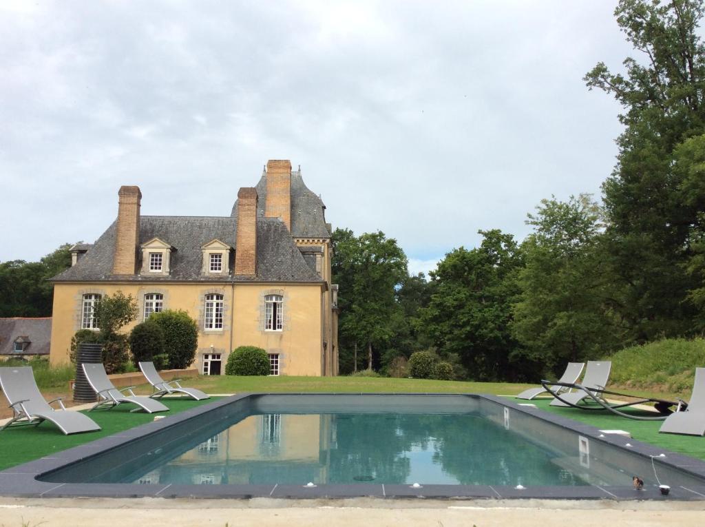 dom z basenem przed nim w obiekcie Château Du Bois Glaume w mieście Poligné