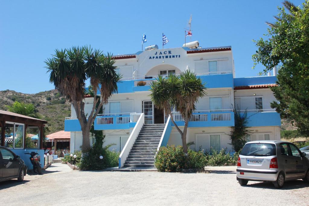 a building with palm trees in front of it at Jack's Apartments in Kefalos