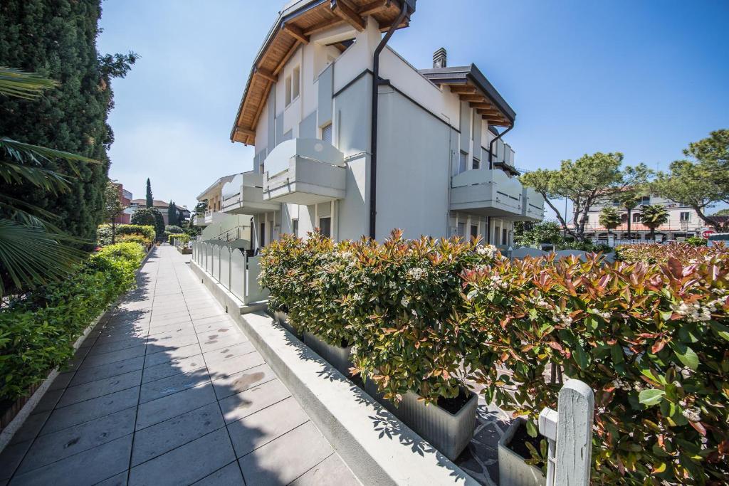 a building with potted plants next to a sidewalk at Monica Appartamenti in Sirmione