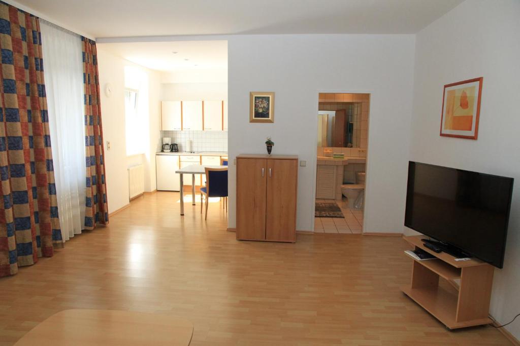 a living room with a television and a kitchen at Appartementhaus Anna in Linz