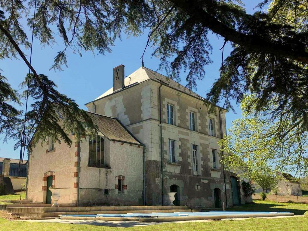 un antiguo edificio con una torre encima en Majestic villa in Cussay with swimming pool en Cussay