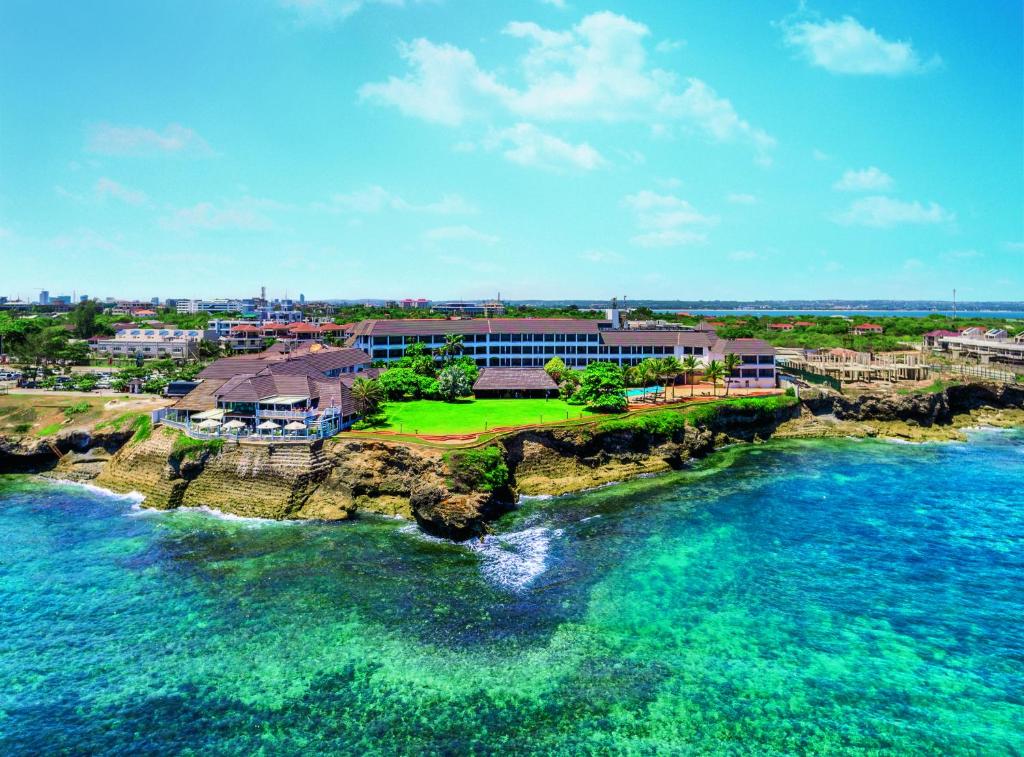 ダル・エス・サラームにあるSea Cliff Hotelの海上の岩の島のリゾートの空中ビュー