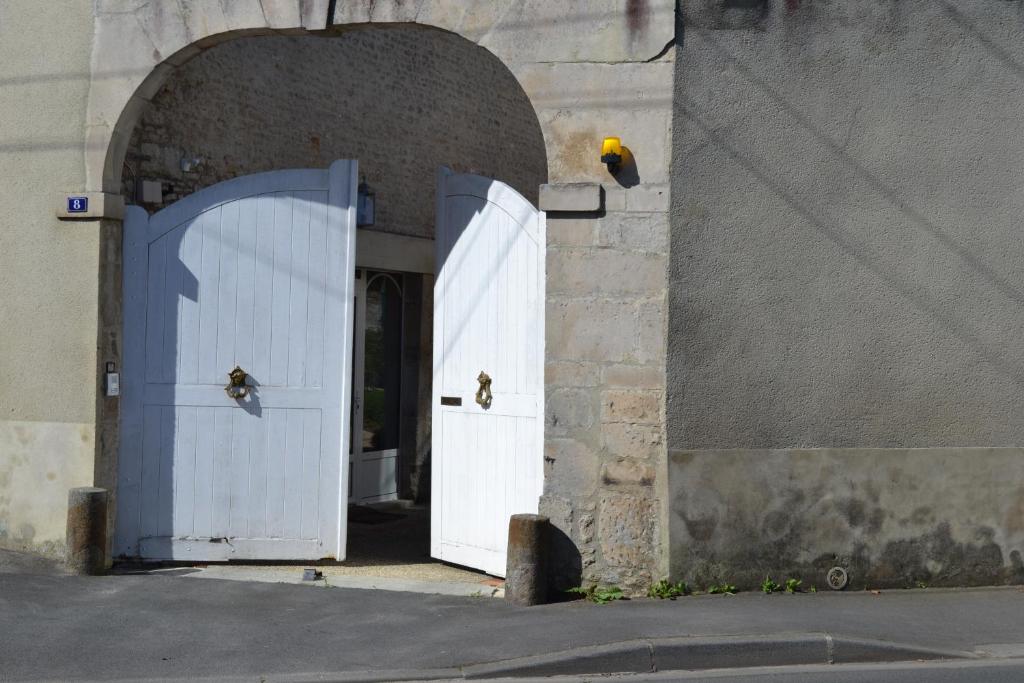 ファレーズにあるLa Maison Des Buisの白い扉が二つあるアーチ道
