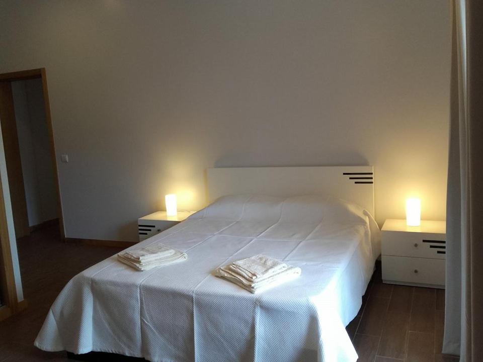 Un dormitorio con una cama blanca con dos velas. en Sweet Home for Holidays, en Machico