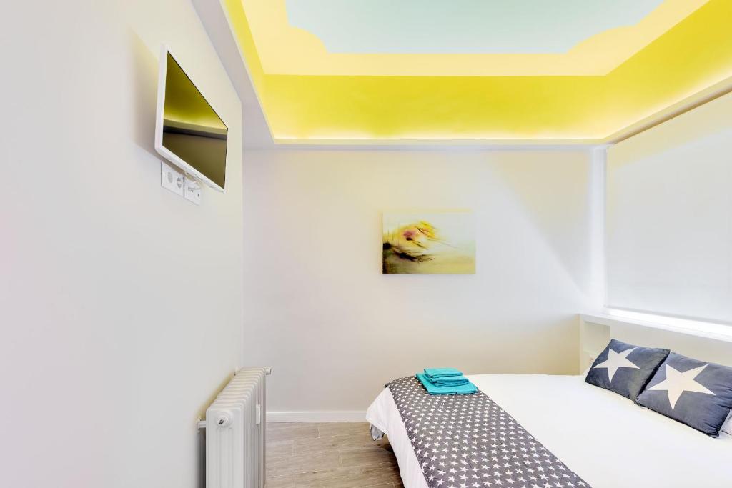 a bedroom with a bed and a yellow ceiling at Apartamento Greco Toledo in Toledo