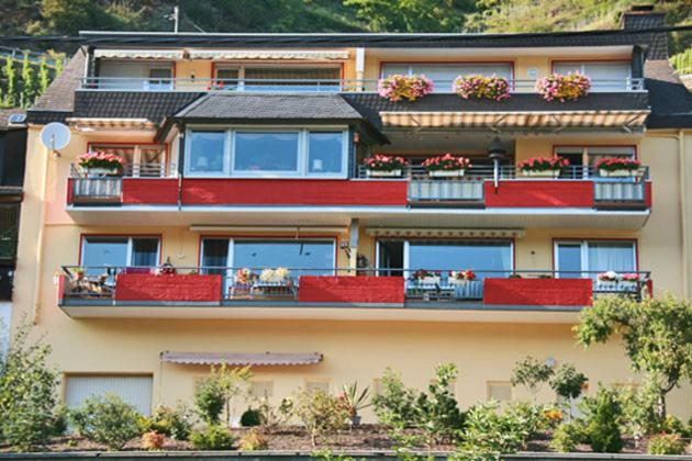 ヴァルヴィヒにあるFerienwohnung Moselblick-Steinの赤いバルコニーと植物が備わる大きなアパートメントです。