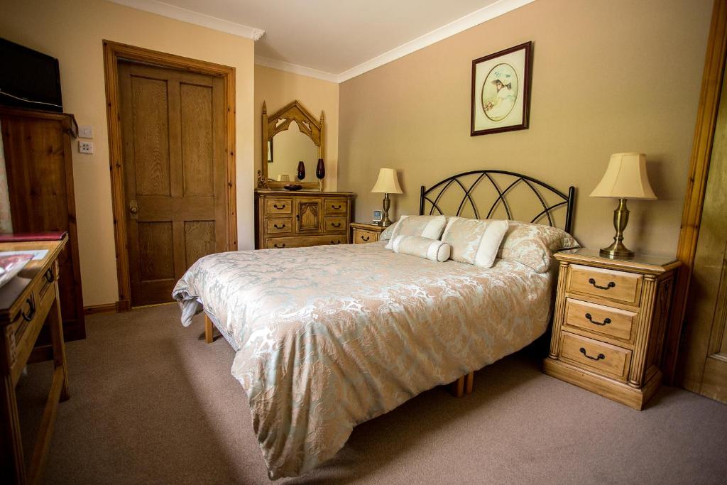 a bedroom with a bed and a dresser and a mirror at Eskview Farm in Montrose