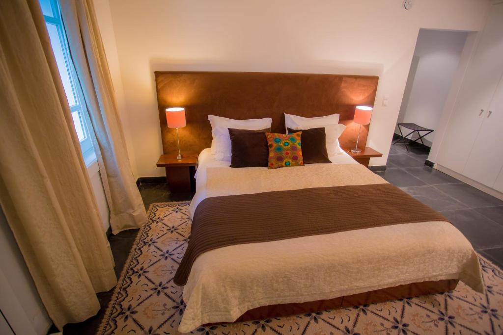 a bedroom with a large bed with two lamps at Quinta Do Convento in Vila Verde dos Francos