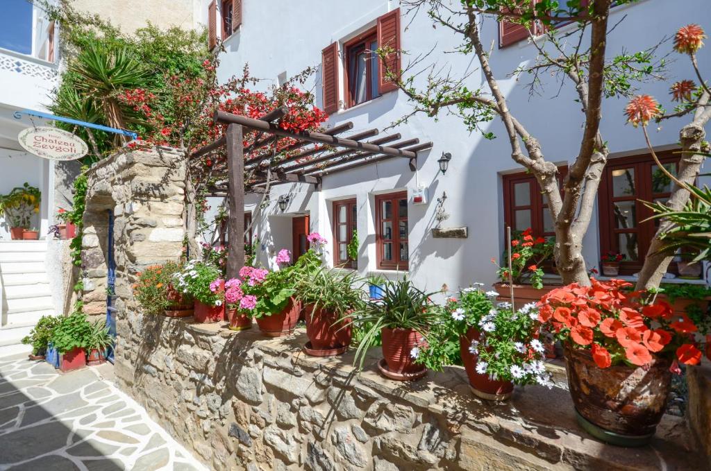 a stone wall with potted plants in front of a building at Chateau Zevgoli in Naxos Chora