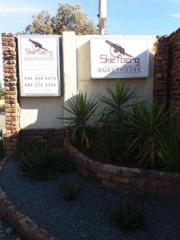 a building with two signs on the side of it at Skietberg Lodge in Colesberg