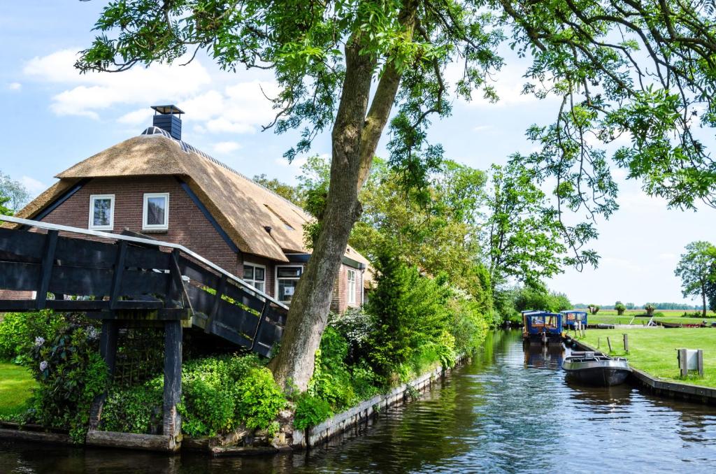 a house on the side of a canal at The Black Sheep Hostel in Giethoorn