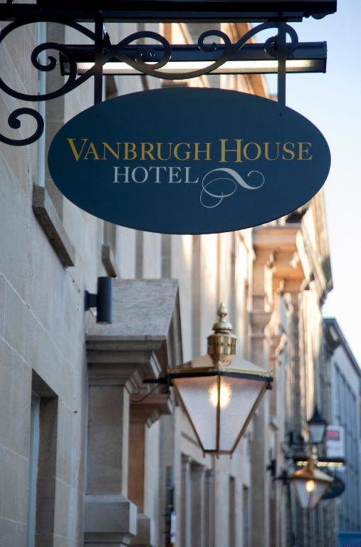 a sign hanging from a building with a street light at Vanbrugh House Hotel in Oxford