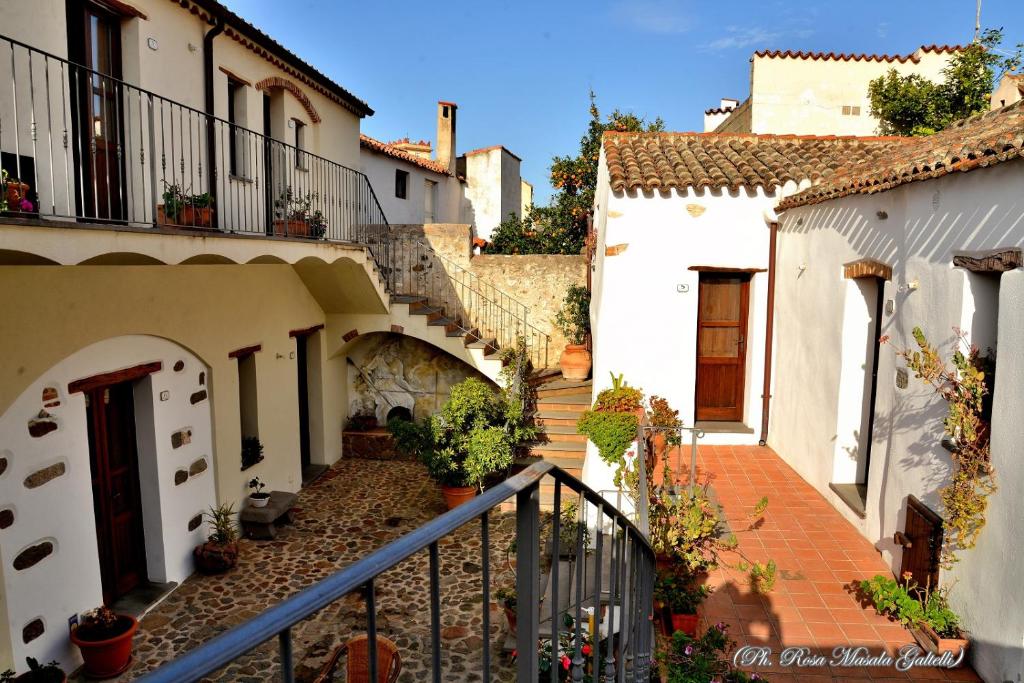 um grupo de casas brancas com escadas e plantas em Antico Borgo em Galtellì