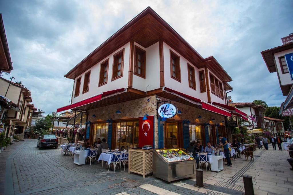a building on a street with people sitting outside of it at Kervan Hotel in Antalya