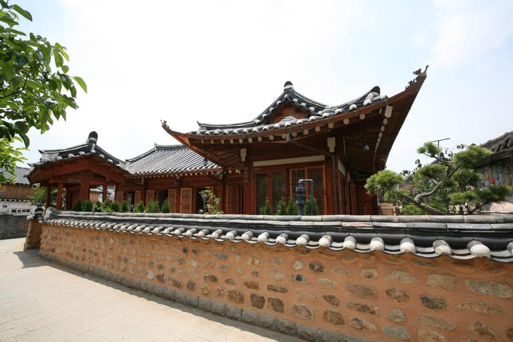 a building behind a brick wall next to a fence at GaEunChae 2 in Jeonju