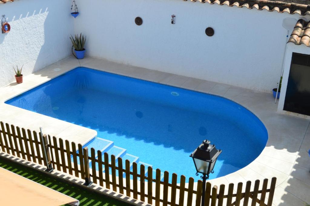 una gran piscina azul con una valla alrededor en El Olivo del Moreno, en Hornachuelos