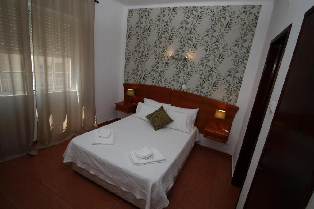 1 dormitorio pequeño con 1 cama con sábanas blancas en Dom Carlos I, en Portimão