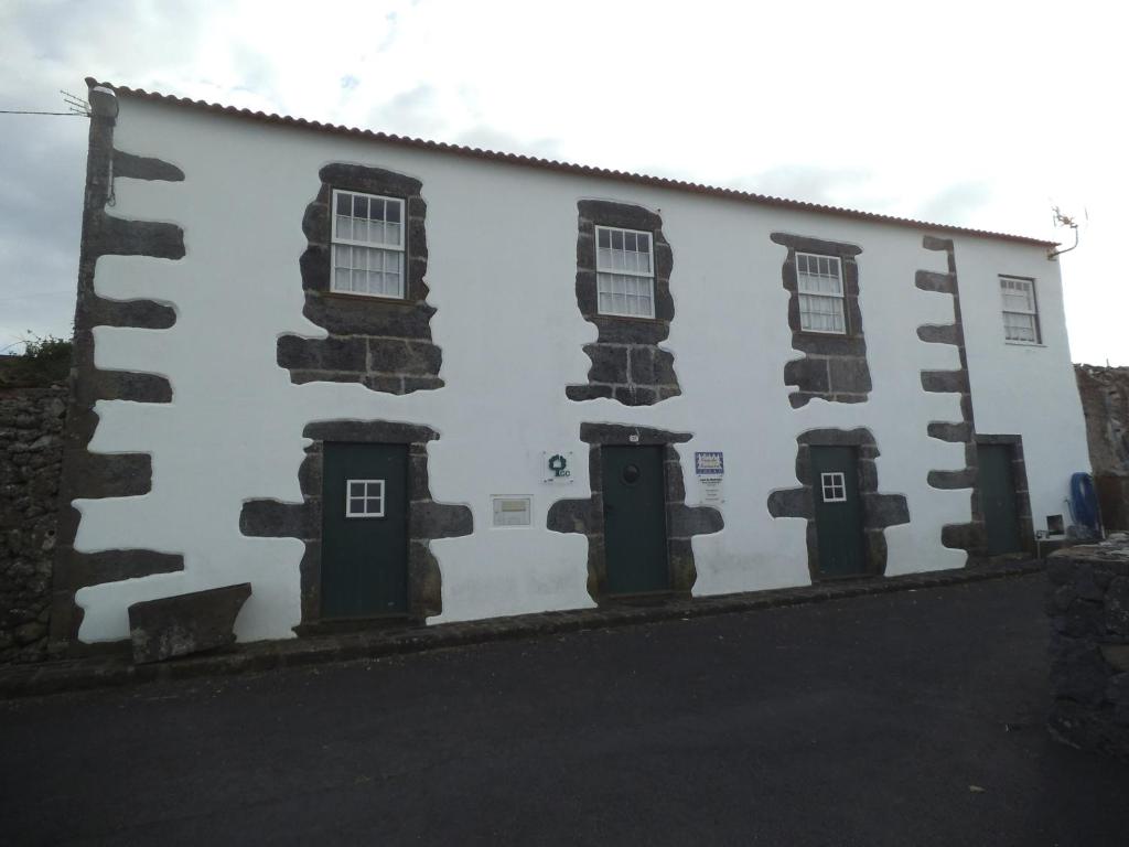 un edificio bianco con finestre e porte di Casa da Madrinha Graciosa a Trás dos Pomares