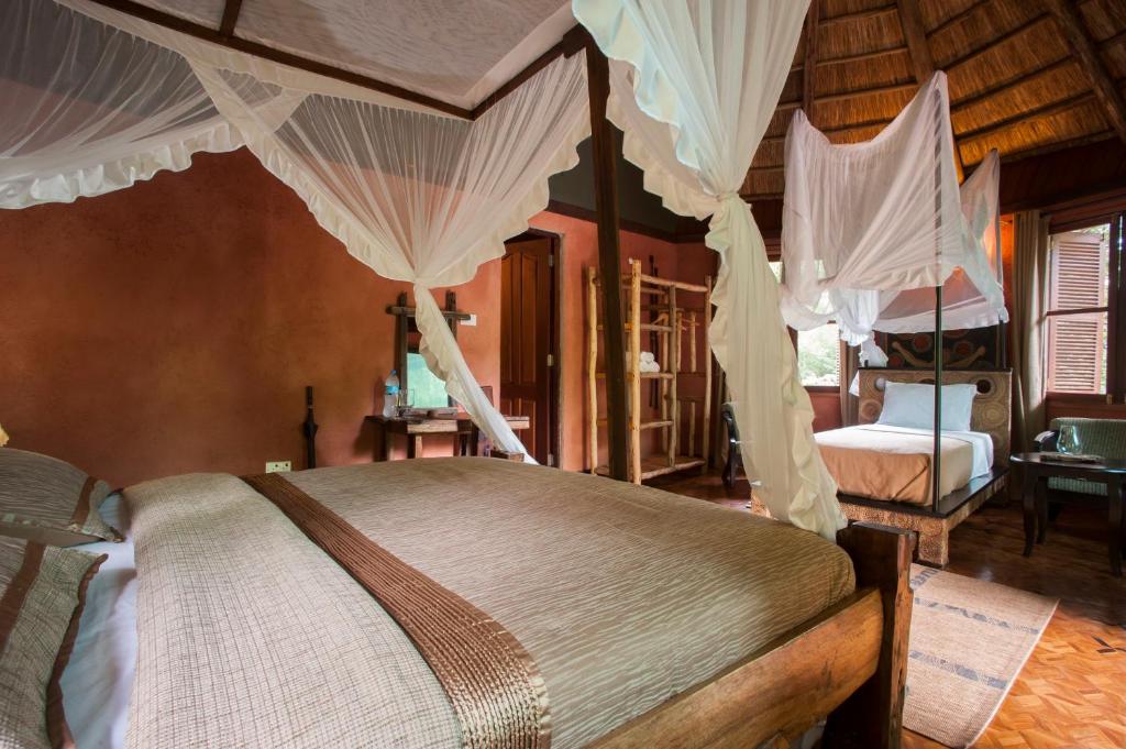 a bedroom with a canopy bed with mosquito nets at Selous Kinga Lodge in Kwangwazi