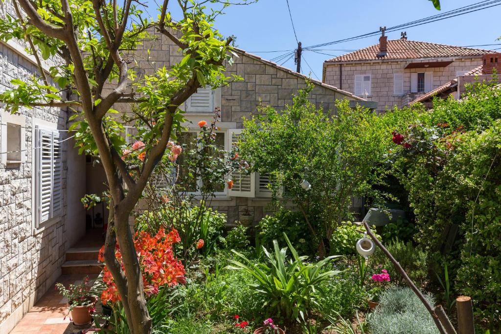 un jardín frente a una casa con flores en Best Apartment Roxy, en Dubrovnik