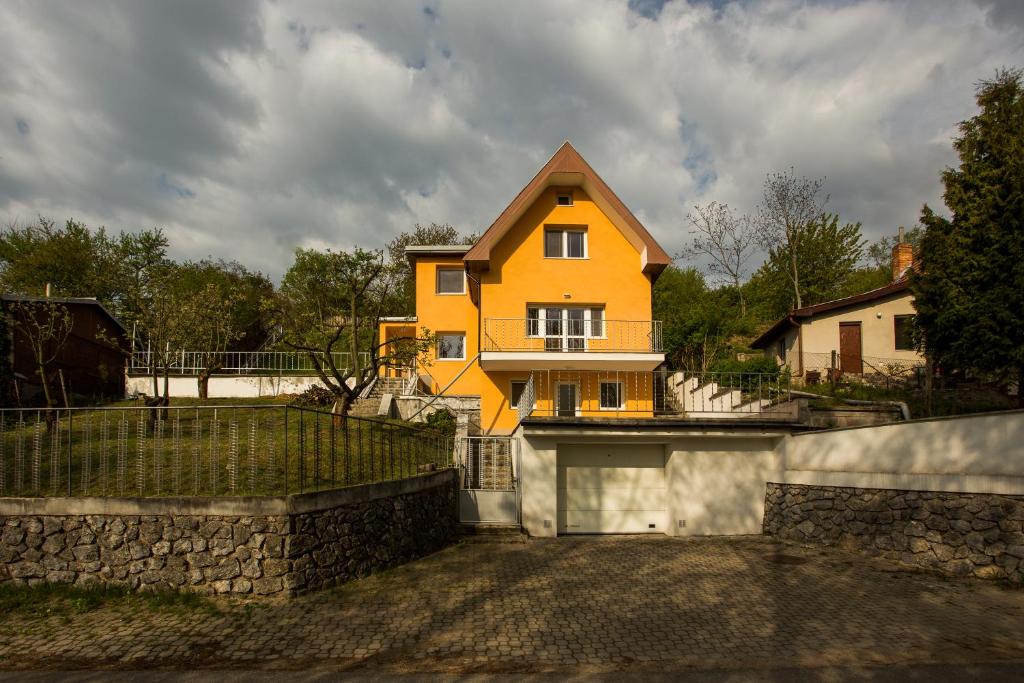 a yellow house with a fence in front of it at Relax na Morave in Němčičky