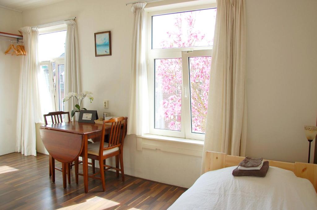 a bedroom with a desk and a table and a bed at Ensche-Day Inn in Enschede