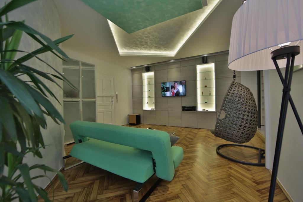 uma sala de estar com um sofá azul e um candeeiro em Apartment Alek em Belgrado
