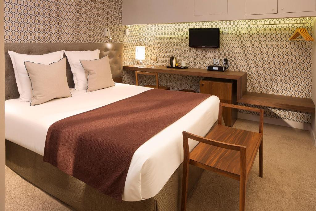 パリにあるホテル ソフィ ジェルマンのベッドルーム(ベッド1台、デスク、テレビ付)