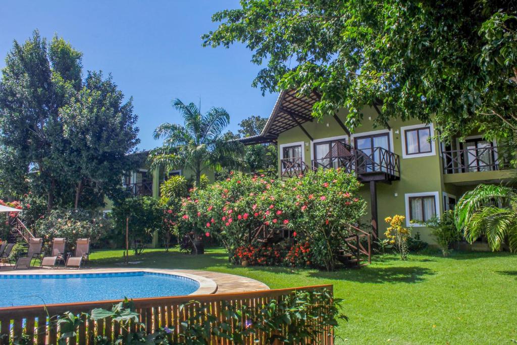 a house with a swimming pool in front of a yard at Recanto da Mata Pipa in Pipa