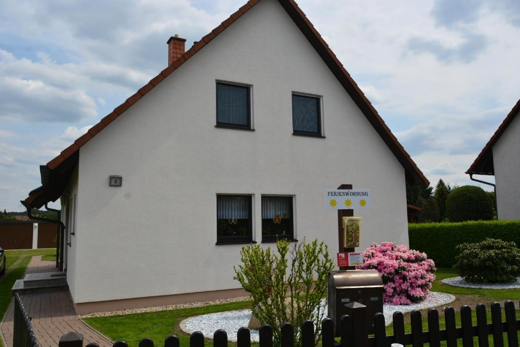 een wit huis met zwarte ramen en een hek bij Ferienwohnung Starke in Gablenz