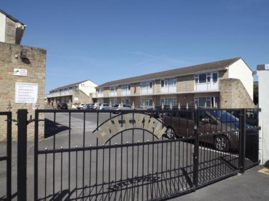 a gate with a car parked in a parking lot at Hill View Apartment in Brean