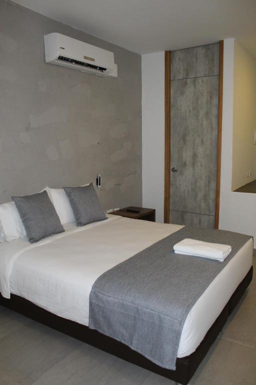 um quarto com uma grande cama branca e uma janela em Hotel Hausen em Lorica