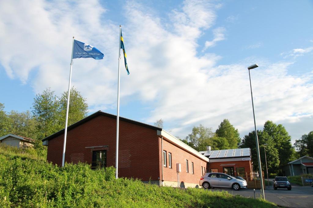 two flags on poles in front of a building at Flygplatshotellet in Landvetter