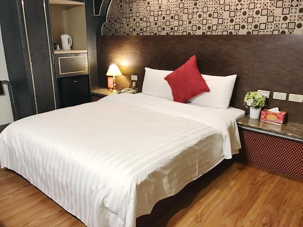 sypialnia z dużym białym łóżkiem z czerwonymi poduszkami w obiekcie Fu Chang Hotel w Tajpej